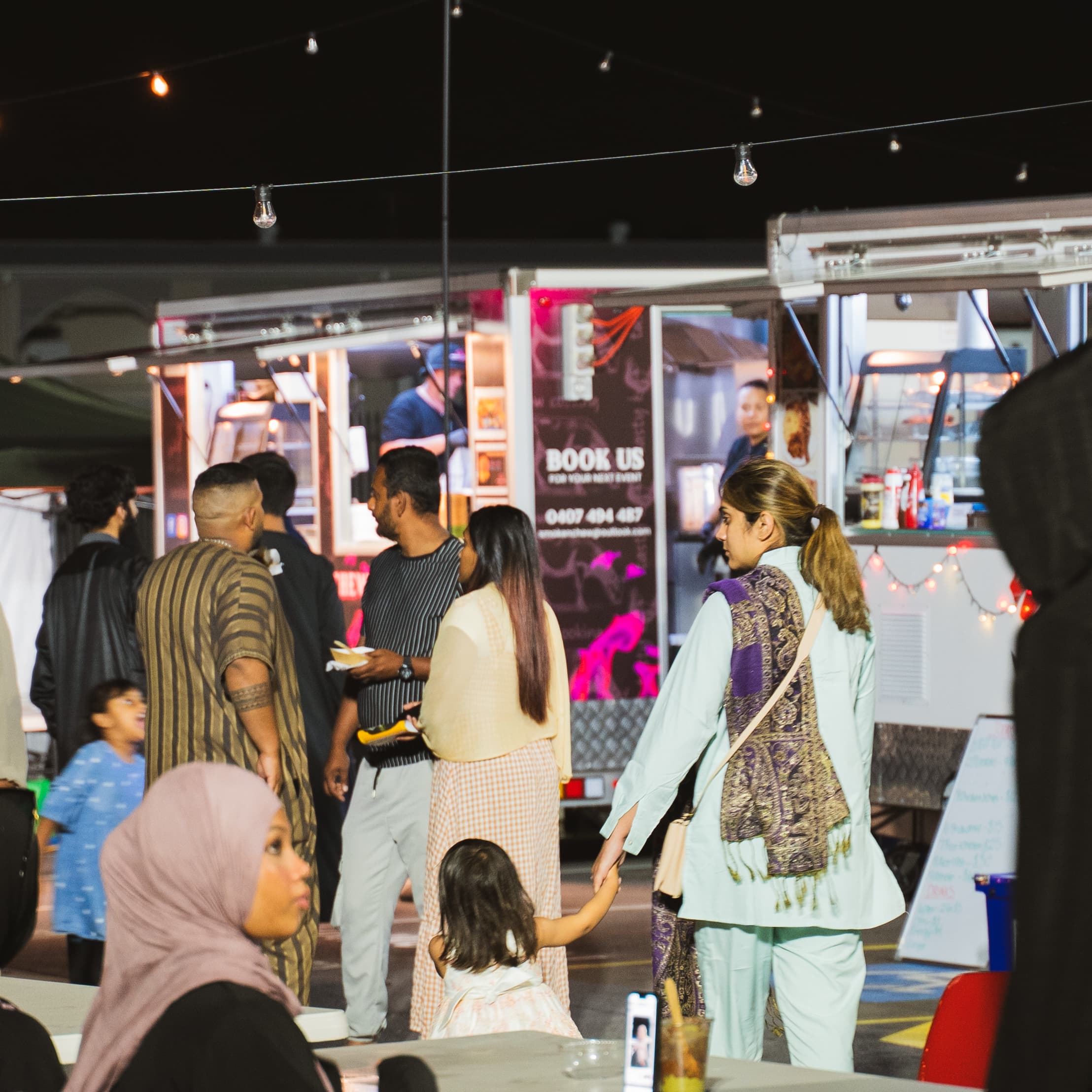 Crowds exploring food trucks at the market